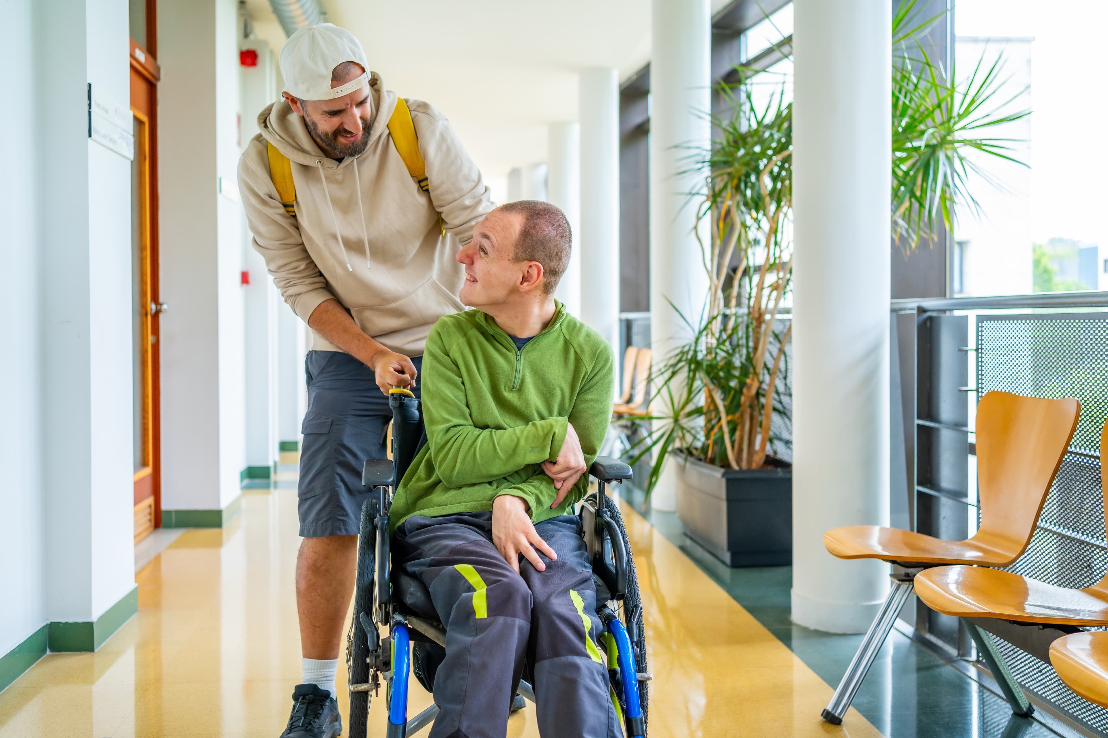 Caregiver supporting a person in a wheelchair in a bright, welcoming environment